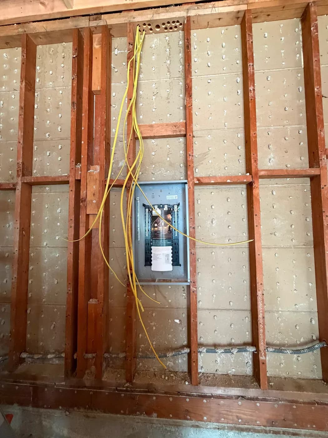 Electrical panel rough-in with new wiring in open wall framing