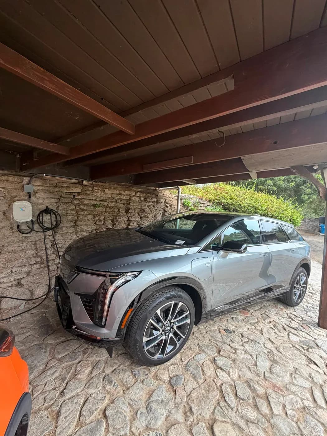 Electric vehicle charging station installed in carport with EV parked