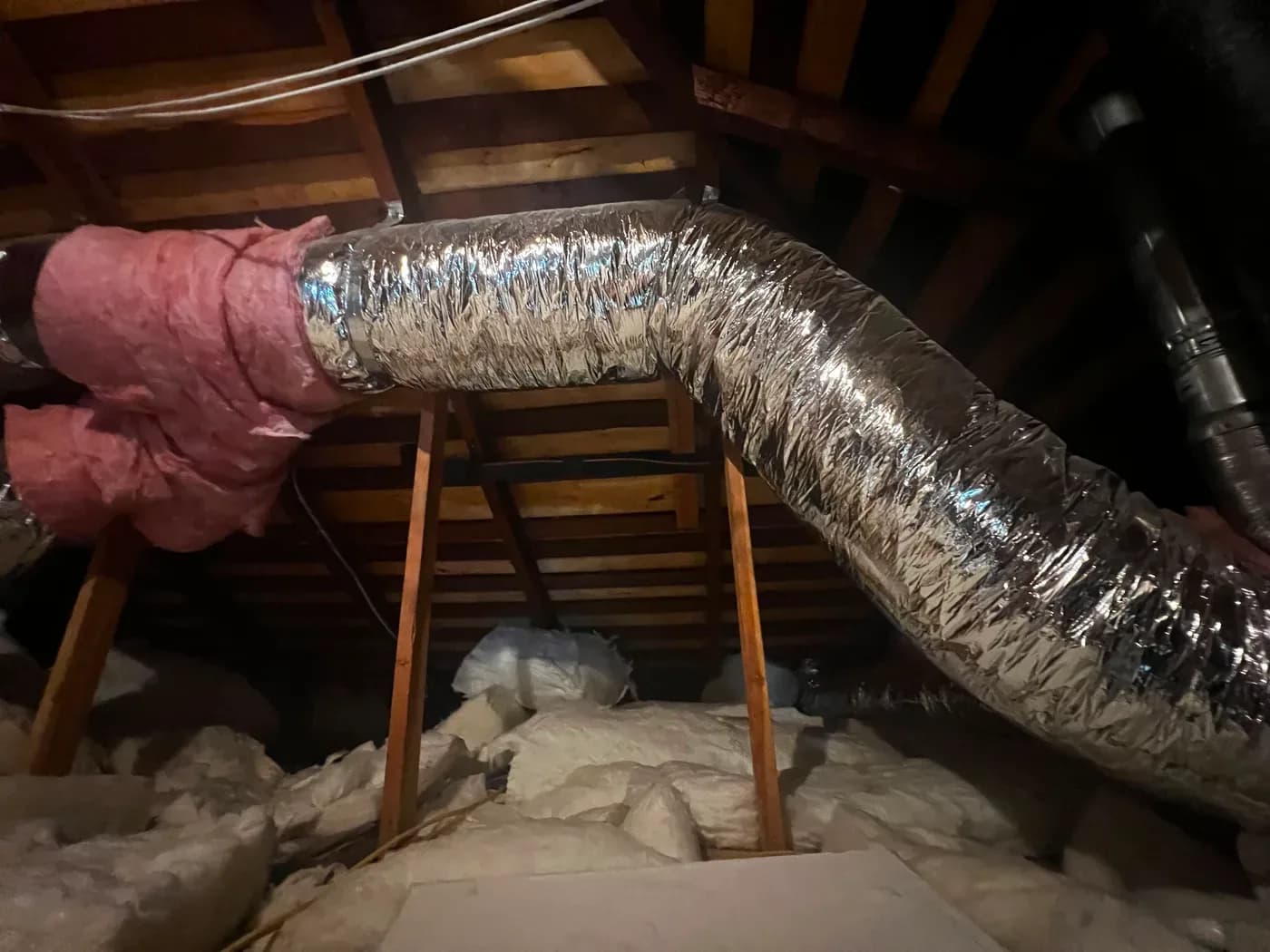 Insulated flexible ductwork routed through attic framing