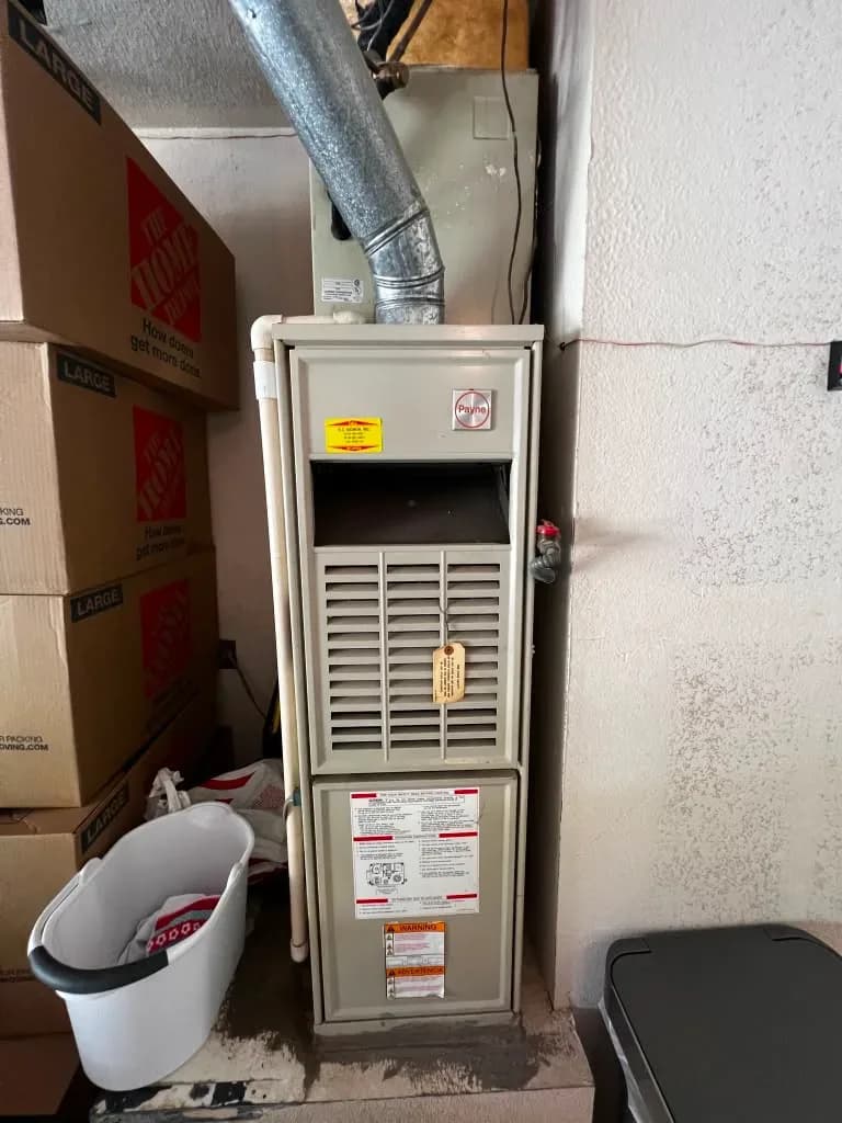 Payne gas furnace installed in a residential utility closet