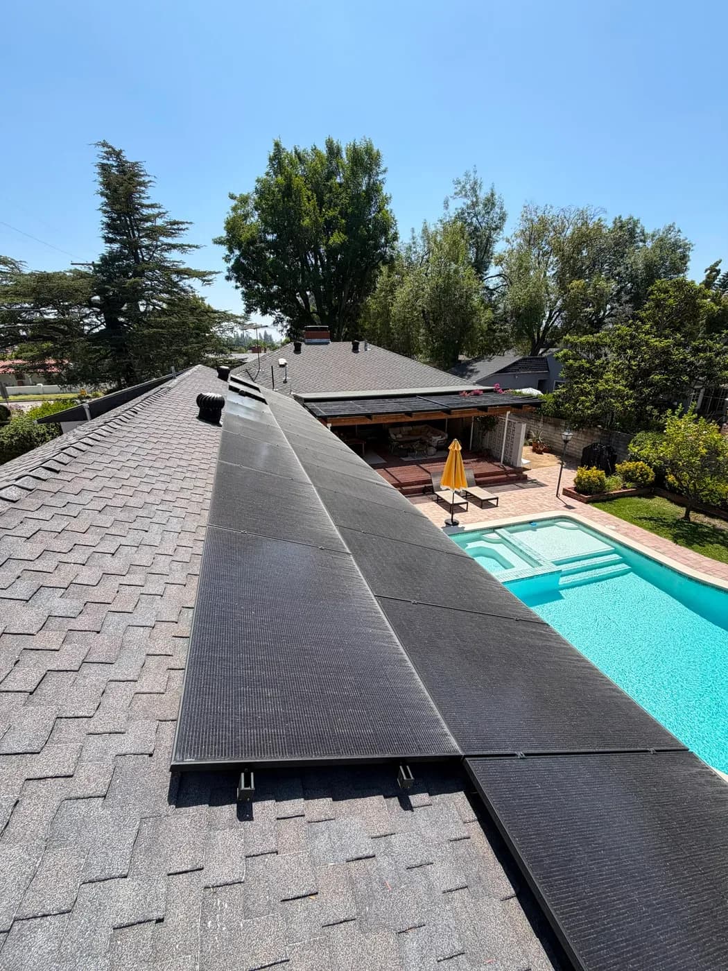 Roof with solar panels installed overlooking backyard pool
