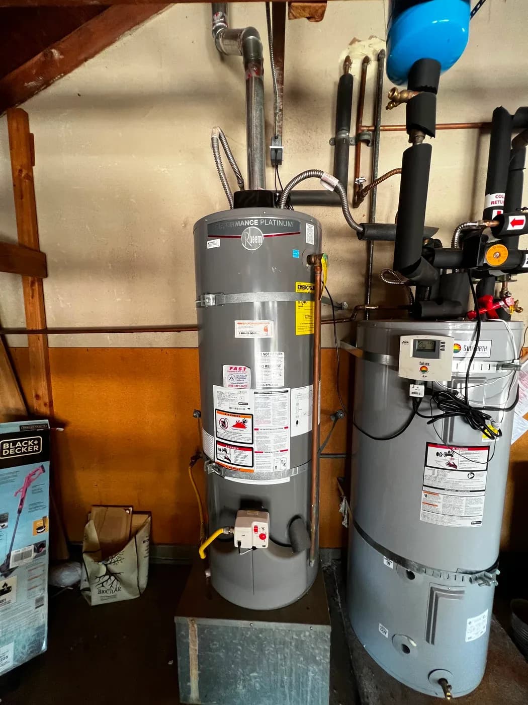 Twin gas and solar storage water heater tanks installed in utility area