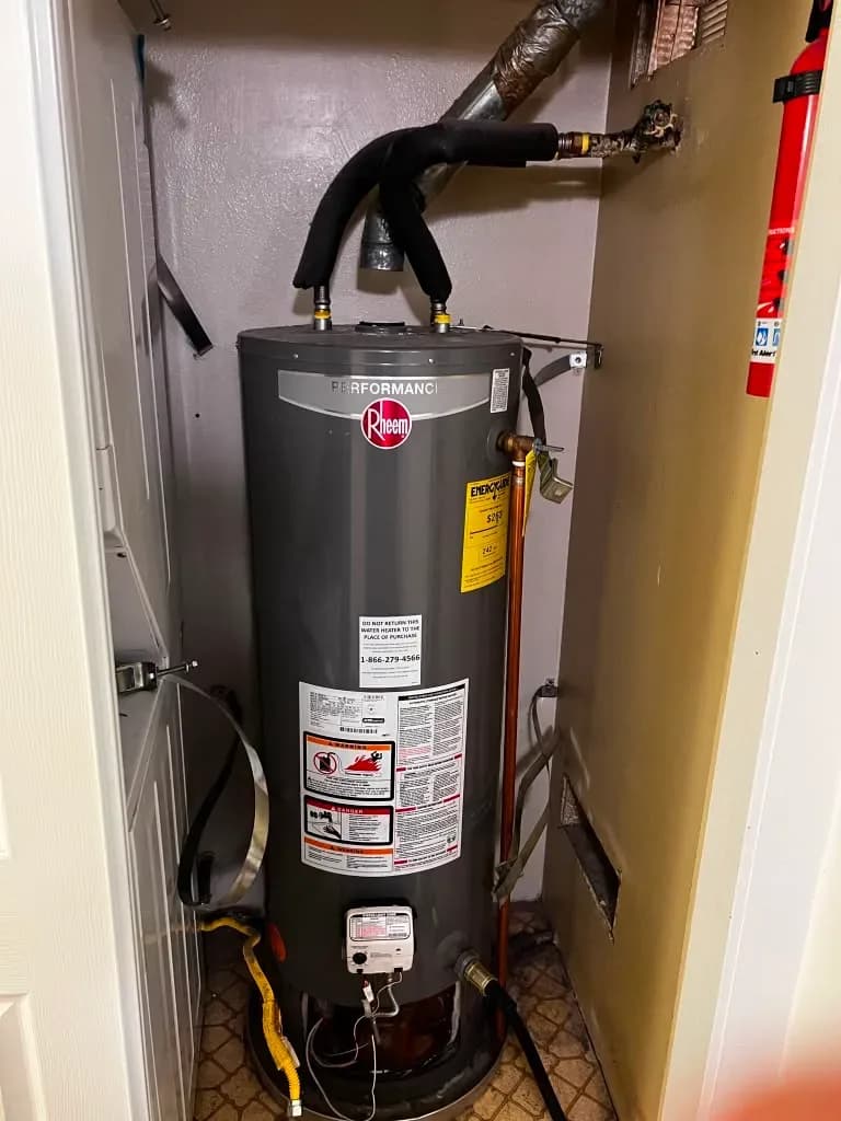 Gas water heater installed in closet with insulated flue piping