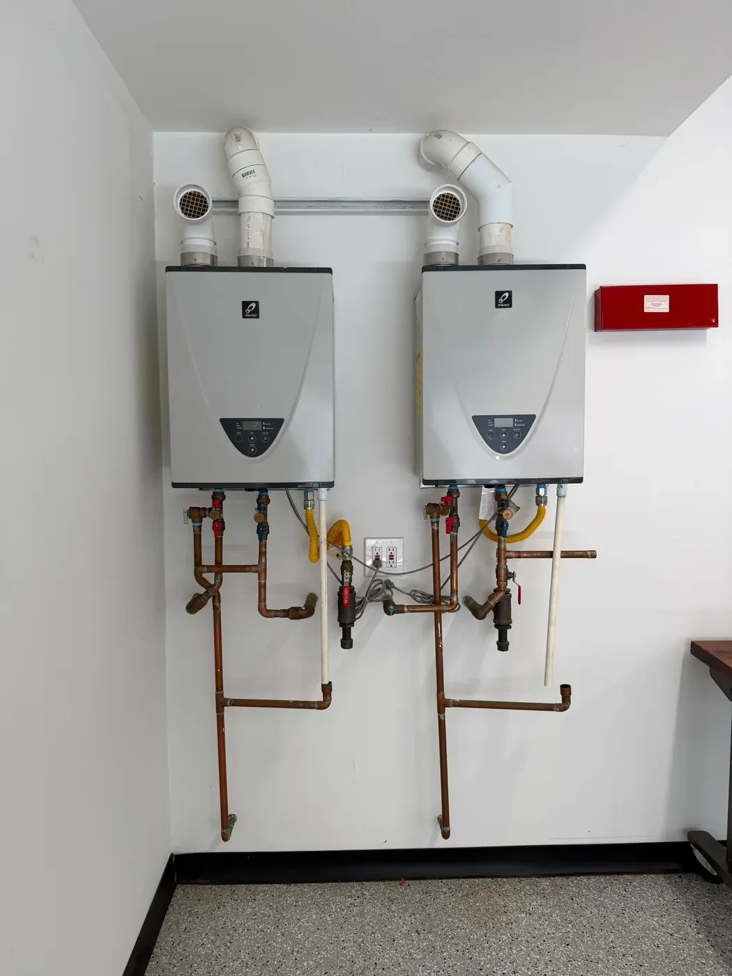 Two Takagi tankless water heaters installed side by side with copper piping